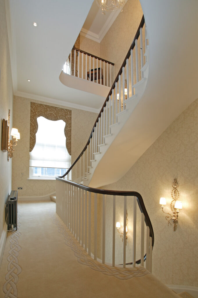 a staircase leading up to a room with a chandelier