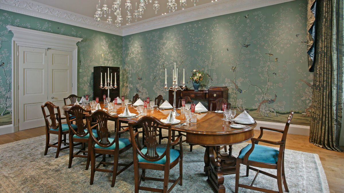 a formal dining room with blue walls and chandelier