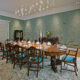 a formal dining room with blue walls and chandelier